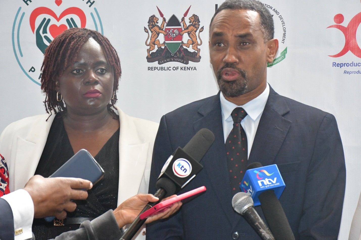 NCPD Director General Dr. Mohamed Sheikh, (Right) flanked by Dr. Nelly Munyasia, Executive Director RHNK fields questions from the media during the launch of Her Health Programme in Narobi.